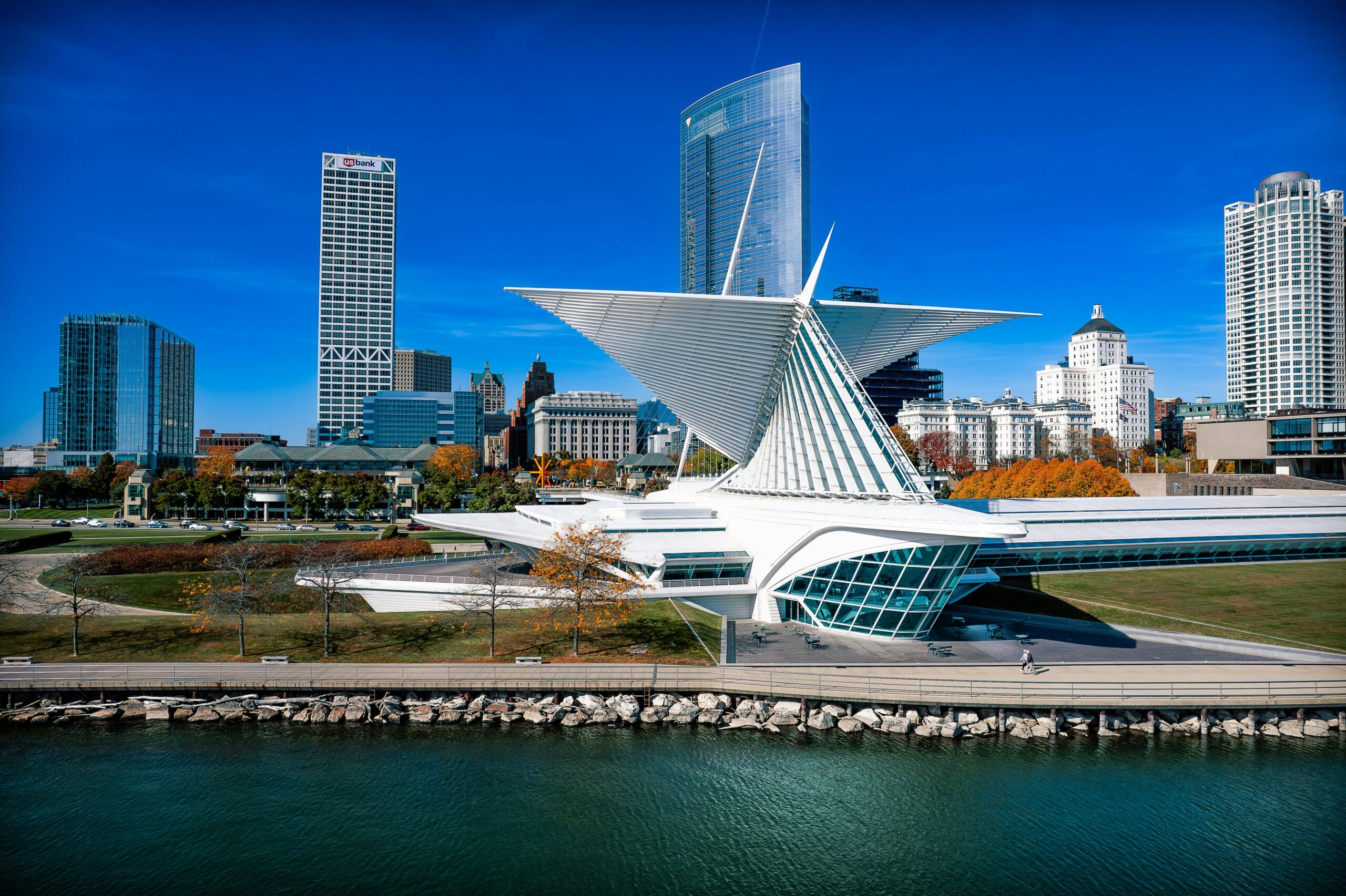 Modern waterfront cityscape with unique architectural structures under a clear blue sky.