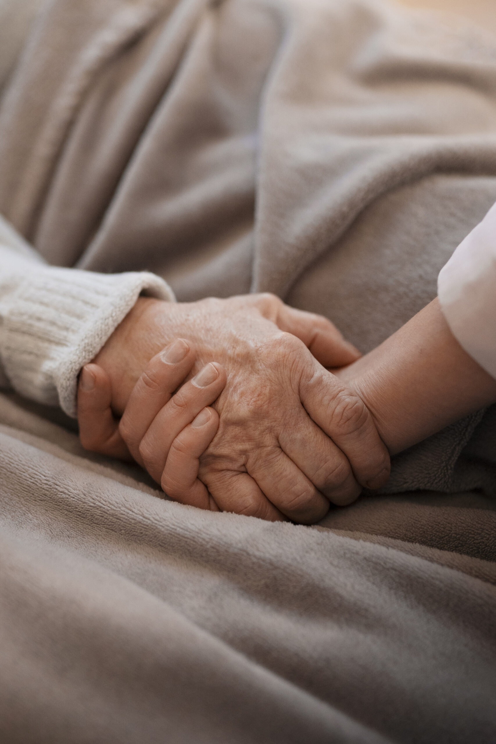 Two people holding hands, showing care and support.